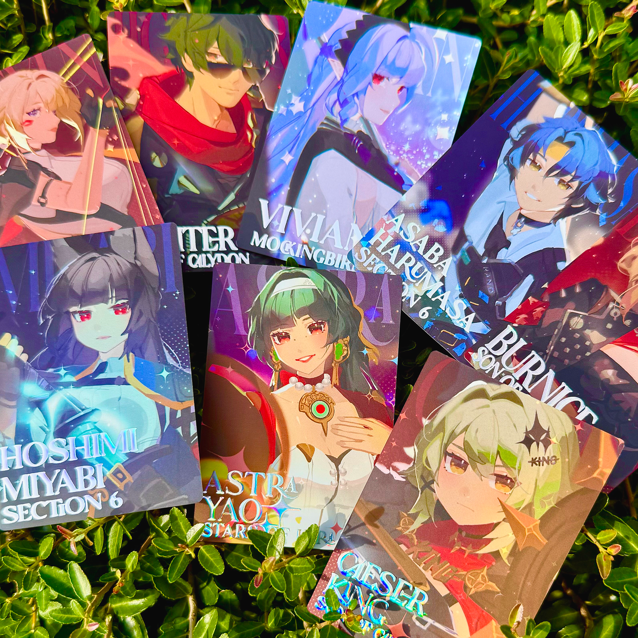 Collection of anime-style trading cards on a green leafy background