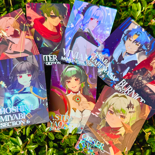 Collection of anime-style trading cards on a green leafy background